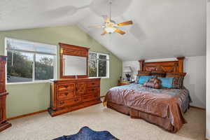 Bedroom with carpet flooring, lofted ceiling, a textured ceiling, and a ceiling fan