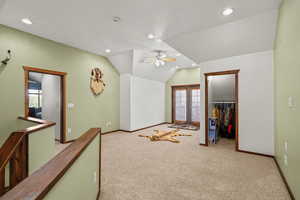 Interior space with french doors, a walk in closet, carpet floors, recessed lighting, and vaulted ceiling