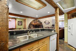 Kitchen featuring white appliances, dark countertops, open floor plan, and recessed lighting