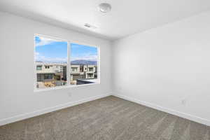 Spare room featuring carpet floors, a textured ceiling, and a mountain view