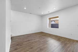 Unfurnished room featuring wood finished floors, recessed lighting, and a textured ceiling