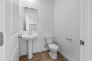 Half bathroom featuring wood finished floors and baseboards