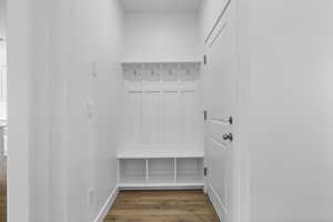 Mudroom featuring dark wood-type flooring and baseboards
