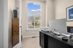 Home office featuring light colored carpet and baseboards