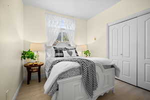Bedroom with light wood-style flooring and a closet