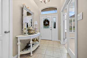 Foyer featuring light tile patterned floors and a chandelier