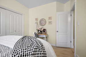 Bedroom with light wood-type flooring and a closet