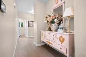 Corridor with baseboards and light wood-style flooring
