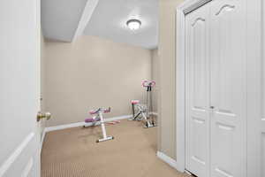 Exercise area featuring baseboards and carpet flooring