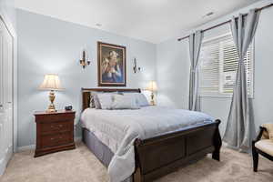 Bedroom with light carpet and a closet