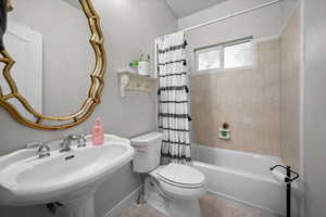 Bathroom featuring shower / bath combo with shower curtain and tile patterned flooring