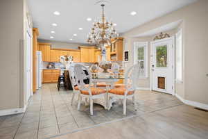 Dining area featuring light tile patterned floors, recessed lighting, and a chandelier