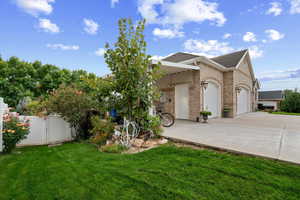 View of front of home with a gate, brick siding, a shingled roof, driveway, and an attached garage