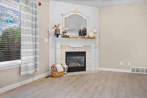 Living room with new light colored LVP floors and a tile fireplace