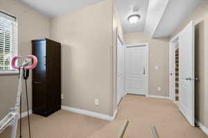 Workout area featuring light carpet and baseboards- Can be bedroom and includes closet, window and extra storage area.