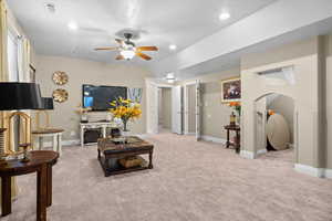 Living area featuring light carpet, a ceiling fan, and recessed lighting