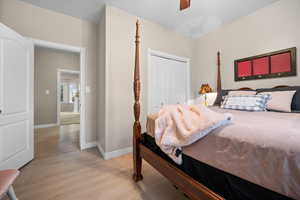 Bedroom featuring light wood-type flooring, a closet, and a ceiling fan