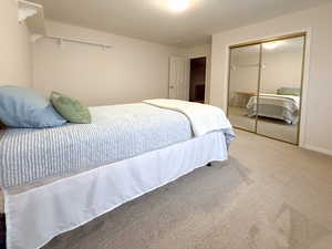 Carpeted bedroom with a closet