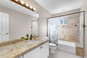 Bathroom with vanity, shower / tub combo, and light tile patterned floors
