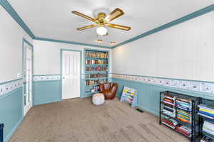 Game room featuring wallpapered walls, ornamental molding, carpet, a ceiling fan, and built in shelves