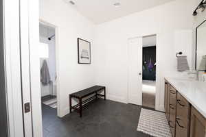 Bathroom with vanity and dark tile patterned flooring