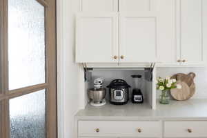 Detailed view of white cabinets and light stone counters