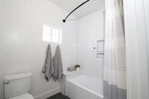Full bathroom with shower / tub combo and dark tile patterned floors