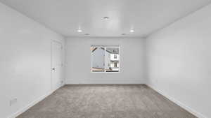 Unfurnished room featuring light carpet and baseboards