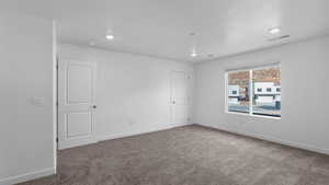 Carpeted empty room with baseboards and recessed lighting