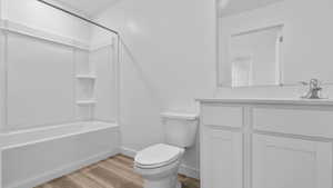 Bathroom with light wood finished floors, vanity, and shower / bathtub combination