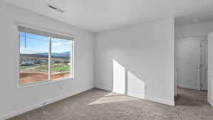 Unfurnished room featuring light colored carpet and a mountain view