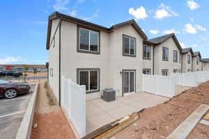 Rear view of property with stucco siding, a residential view, and a patio area