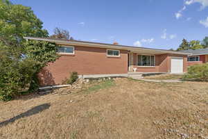Ranch-style house with brick siding, a garage, and a front yard