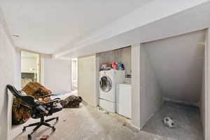 Laundry area featuring a textured ceiling and washing machine and clothes dryer