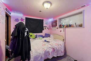 Carpeted bedroom featuring a textured ceiling