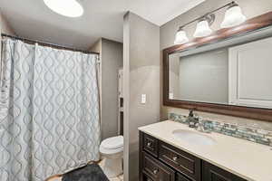 Bathroom with a textured wall, vanity, tasteful backsplash, a textured ceiling, and a shower with shower curtain