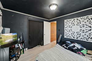 Bedroom featuring ornamental molding and light wood finished floors