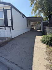View of property exterior featuring a shed, an attached carport, and driveway