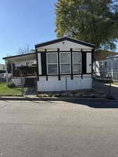 Manufactured / mobile home with a carport and a fenced front yard