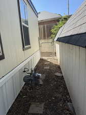 View of side of home featuring a gate