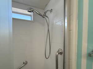 Bathroom featuring shower / washtub combination and a textured ceiling