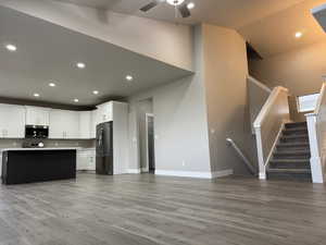 Kitchen with recessed lighting, open floor plan, white cabinets, light countertops, and light wood-style floors