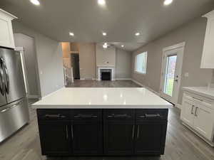 Kitchen featuring dark cabinetry, white cabinets, recessed lighting, freestanding refrigerator, and light wood finished floors