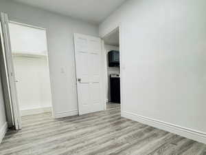 Unfurnished bedroom with light wood-style floors and a spacious closet
