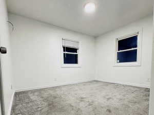 Carpeted empty room featuring baseboards