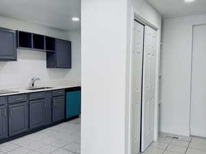 Kitchen with light tile patterned floors, light countertops, dishwasher, open shelves, and recessed lighting