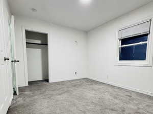 Unfurnished bedroom featuring carpet flooring and a closet