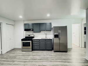 Kitchen featuring light wood-style floors, stainless steel appliances, recessed lighting, and light countertops