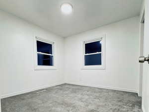 Empty room with carpet floors and baseboards
