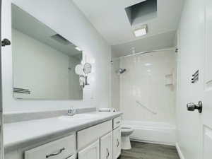 Bathroom with shower / washtub combination, vanity, and light wood-type flooring